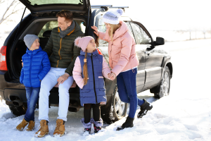 glückliche Familie am Kofferraum vom Auto