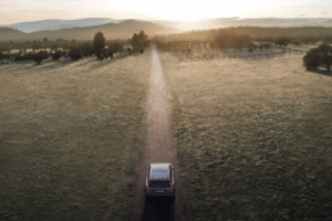 Elektroauto auf Landstraße bei Sonnenuntergang